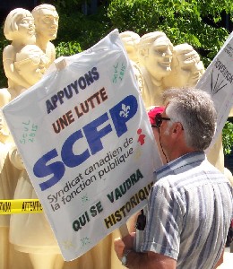 Une lutte SCFP historique. Défilant devant l’édifice de la Caisse de dépôt et placement du Québec, le 19 juin 2002, ce manifestant avait vu juste. Rappelons que le 8 mai, l'an dernier, les syndiqués de Vidéotron entraient en grève pour être mis en lock-out 14 minutes plus tard par leur employeur. Probablement le plus important des dix dernières années, ce conflit de travail pourrait se terminer très bientôt. <br>Photo Service de l’information SCFP (Archives)